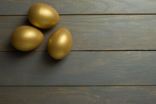 Gold eggs over a wood background