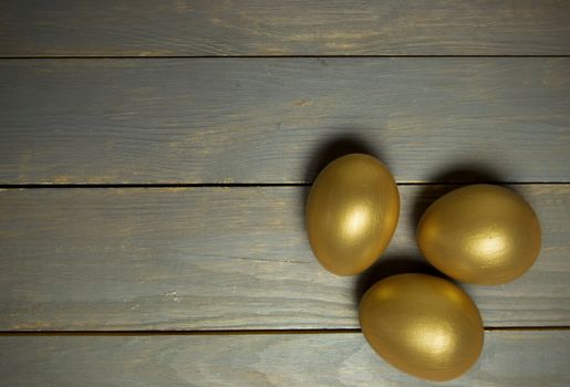 Gold easter eggs over a wood background