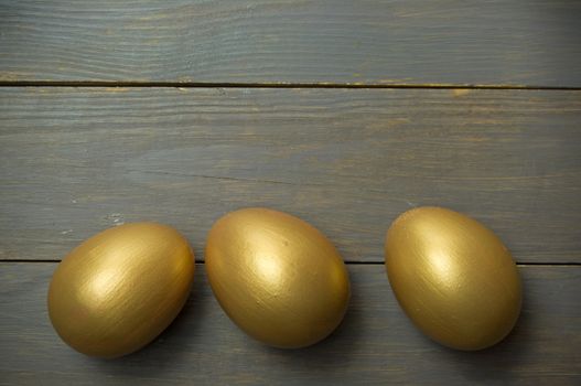 Gold eggs over a wood background