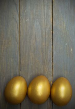 Golden easter eggs over wood