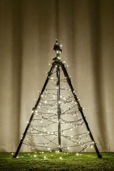 Christmas tree made of camera tripod, decorated by the lights