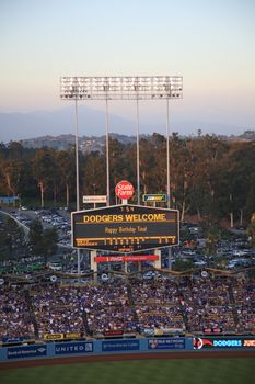 Dodger Stadium scoreboard at dusk during a Dodgers baseball game in Los Angeles