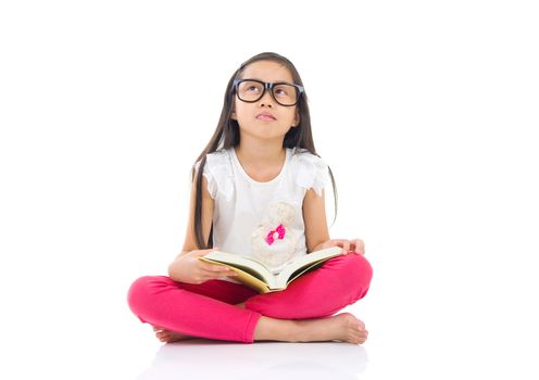 Asian girl wearing spectacles sitting on the floor with books