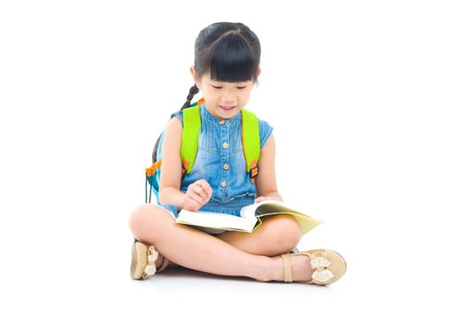 Asian preschool girl with schoolbag and books sitting on the floor