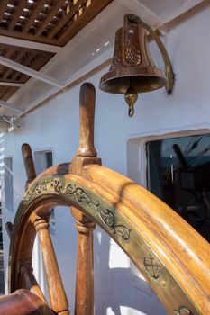 Steering wheel and bell on ship