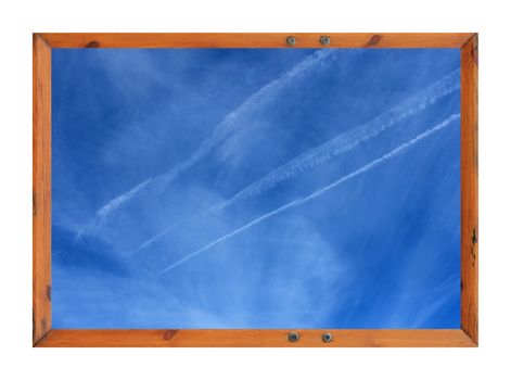 Scenic view of white vapor trails in blue sky surrounded by a wooden picture frame.
