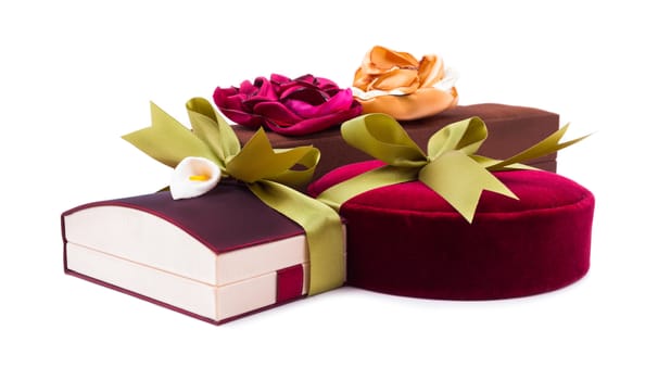 Luxury gift boxes in dark red and brown shades with green satin ribbon and bow isolated over white background.