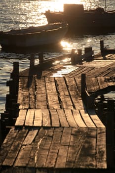 Wooden pier with boats at sunset