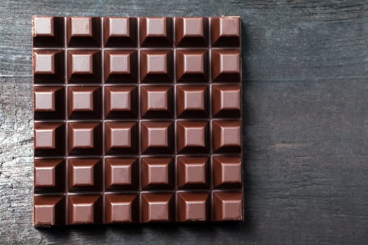 Dark chocolate bar on wooden background