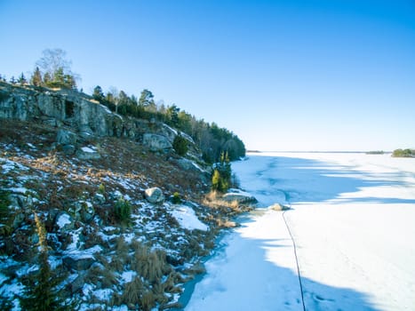 Frozen shoreline in winter and a blue sky