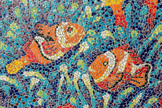 Colorful glass mosaic art shape fish and abstract wall background.