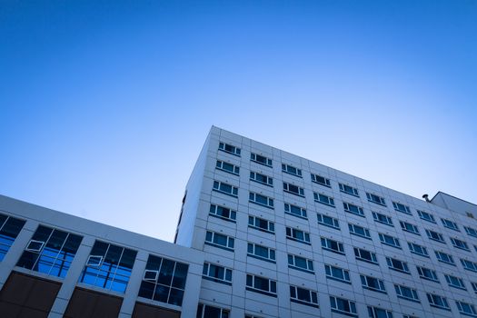 square side of pane in business center over blue bright sky.