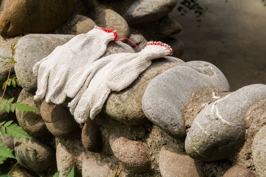 Gloves workers were left on a stone wall.