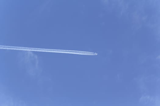 the plane is flying in the sky leaving a white trail