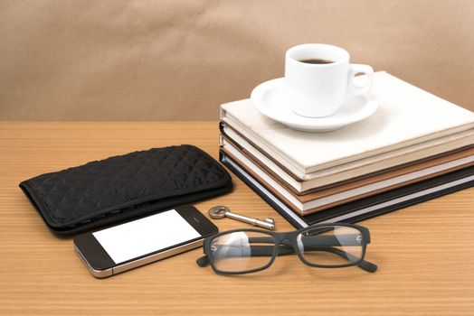 coffee and phone with stack of book,key,eyeglasses and wallet on wood background