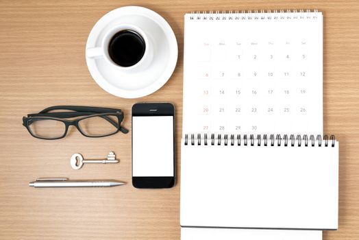 coffee and phone with key,eyeglasses,notepad,calendar on wood table background