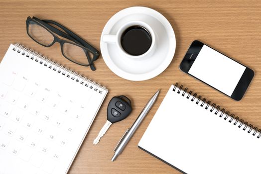 coffee and phone with car key,eyeglasses,notepad,calendar on wood background