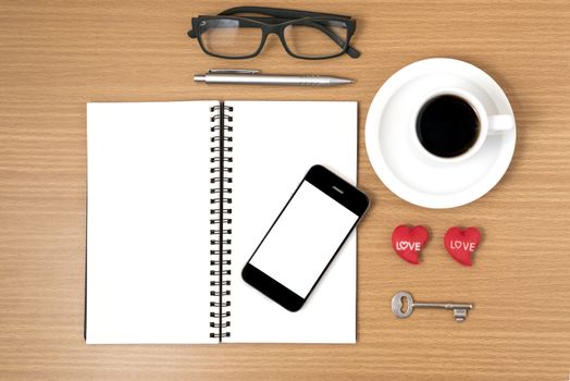 office desk : coffee and phone with key,eyeglasses,notepad,heart on wood background