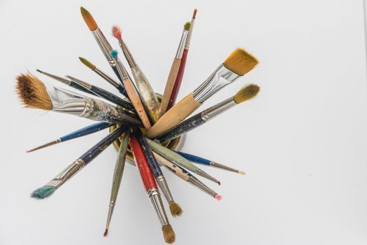 Photo of artist paint brushes in a jar. Top view with copy space.