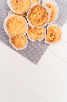 Close up of homemade coconut macaroons, cookie recipe in the oven on rustic wooden background. Top view with copy space.