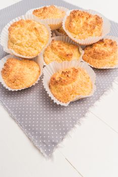 Close up of homemade coconut macaroons, cookie recipe in the oven on rustic wooden background. Top view with copy space.