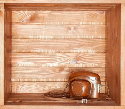 vintage old camera in brown case on wooden shelf