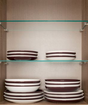 mixed clean white and brown dishes placed on a wooden  and glass shelf