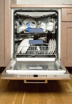 Utensils in dishwasher, opend door, kitchen furniture