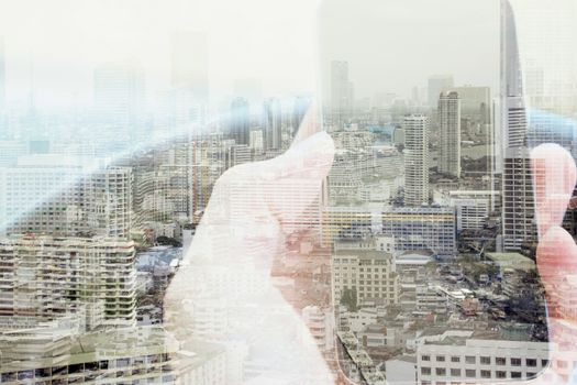Double exposure of man using smart phone and cityscape background, urban lifestyle and Business technology concept.