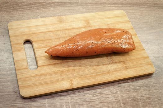 smoked turkey meat on wooden chopping board , wooden table background