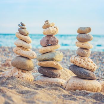 Three stacks of round smooth stones on the beach