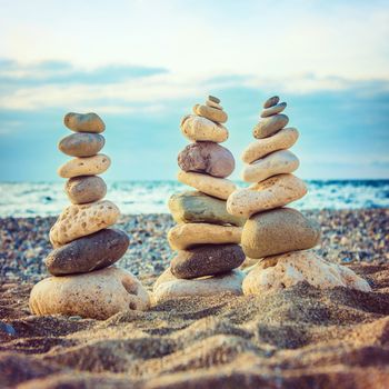 Three stacks of round smooth stones on the beach