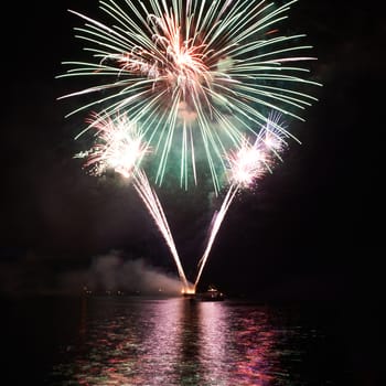 Green colorful fireworks on the black sky background