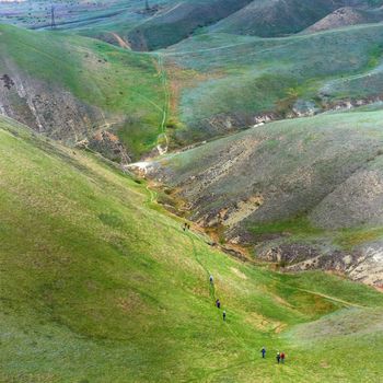 Group of people hiking in the green mountains