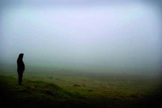 A lone man stood in the mist on the preseli mountains.