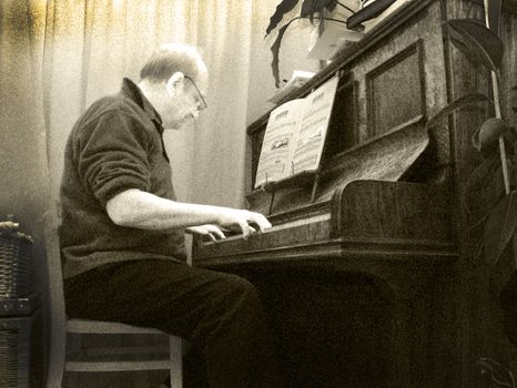 A black and white image of an old blues pianist