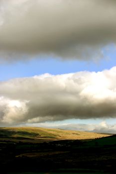 The Welsh hills and valley set within a cloudy sky background