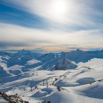 Snowy blue mountains in clouds. Winter ski resort