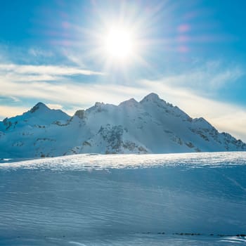 Snowy blue mountains in clouds. Winter ski resort