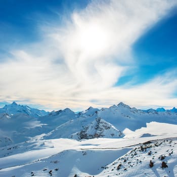 Snowy blue mountains in clouds. Winter ski resort