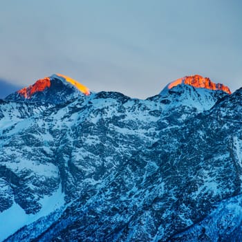 Red sunset in mountains covered by snow.