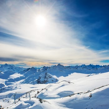 Snowy blue mountains in clouds. Winter ski resort