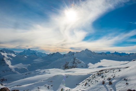 Snowy blue mountains in clouds. Winter ski resort