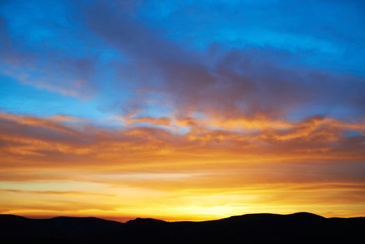 Land with and dramatic colorful sky at sunset