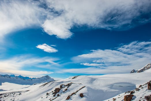 Snowy blue mountains in clouds. Winter ski resort