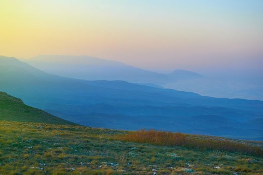 Sunset in the mountains. Sun and blue fog on background