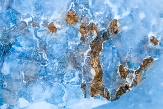 Frozen waterfall of blue icicles on the rock