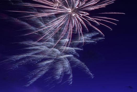 Blue colorful fireworks on night sky background