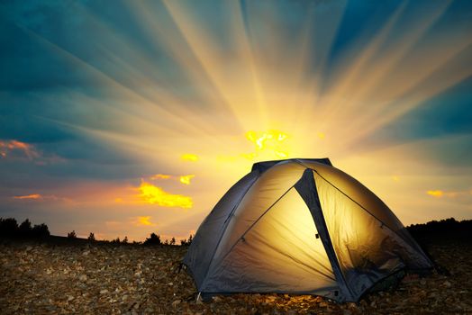 Illuminated yellow camping tent under stars at night. Instagram like filter