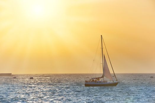 Sail boat against sea sunset. Colorful marine landscape.